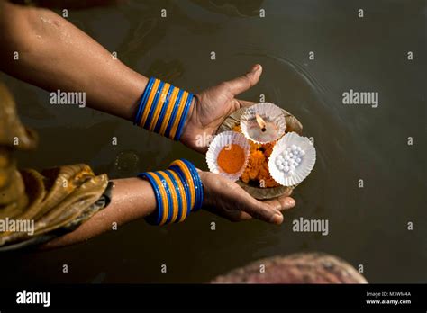 india varanasi ganga river ghats hindu pilgrim woman placing floating candles on ganges