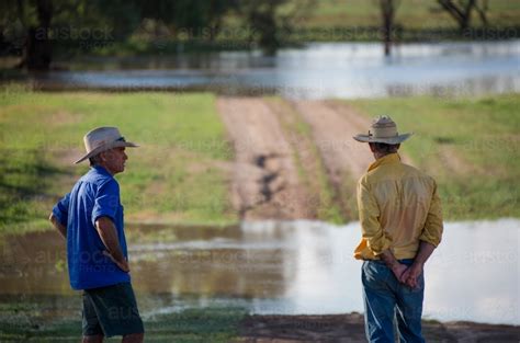 Image Of Two Farmers Talking Near A Flooded Creek Austockphoto