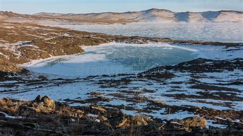 A Small Frozen Heart Shaped Lake Is Surrounded By Hills Stock Image