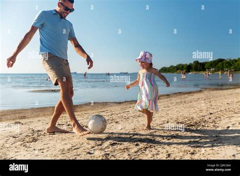 Feliz Padre E Hija Jugando A La Pelota En La Playa Fotografía De Stock