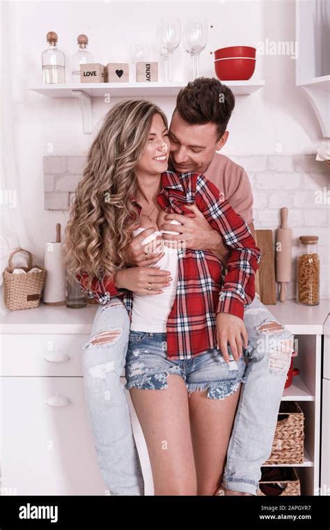 Happy Young Couple In Love Are Hugging And Having Fun In The Kitchen On