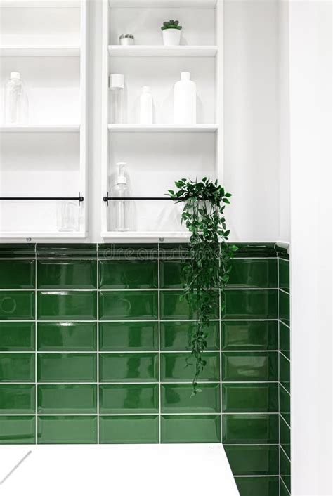 Bathroom Interior With Green Tiles And White Cabinets On The Wall