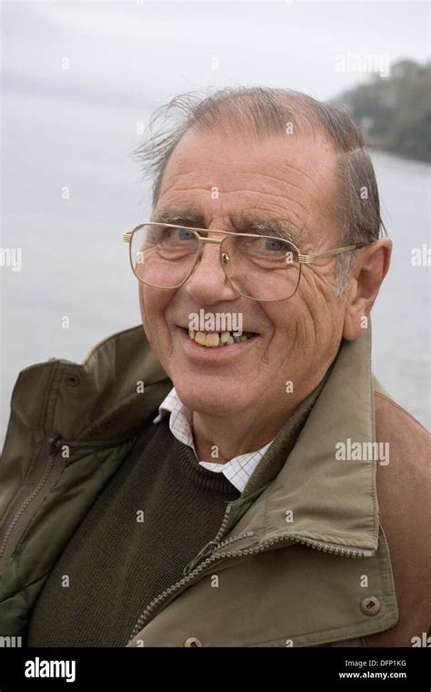 75 Year Old Man Smiling Into Camerawearing Glasses On The Beach