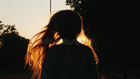 Silhouette Of A Girl With Long Hair Shakes His Head And Plays With His
