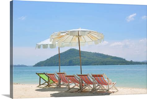 Beach Chair And Umbrella On Beach And Rang Yai Island Background Wall