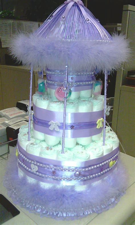 She placed rolled onesies, sock rattles, bath frogs, bobble heads and washcloth lollipops through out for decoration. Carousel diaper cake | Baby shower diapers, Baby diaper ...