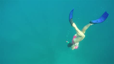 Underwater Angle Looking Up Of Woman Snorkeling In Blue