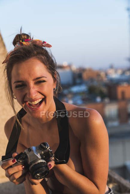 Rire seins nus jeune femme avec caméra sur le balcon Milléniaux Sans