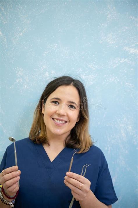 Cheerful And Beautiful Dentist Holding Instrumentation And Smiling In