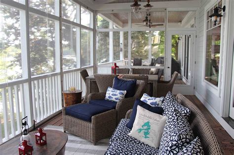 A Screened Porch With Wicker Furniture And Blue Pillows