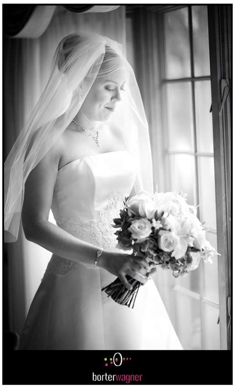 Black And White Bridal Portrait Bride Looking At Flowers Framed By
