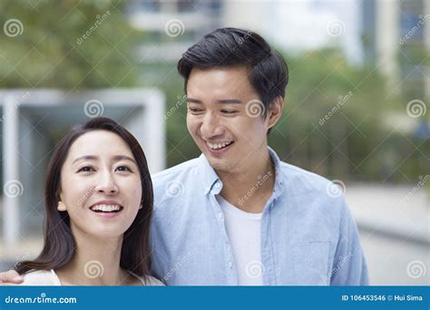 Portrait Of Young Chinese Couple Standing And Smiling Outdoor Stock Photo