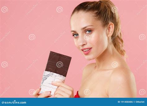 blonde halve naakte vrouw 20 s perfecte huidgenade omhoog in hand chocoladestaaf