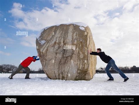 2 Men Pushing Boulder Stock Photo Alamy