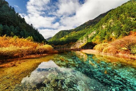 Crystal Clear Water Of River Among Mountains In Autumn Stock Photo