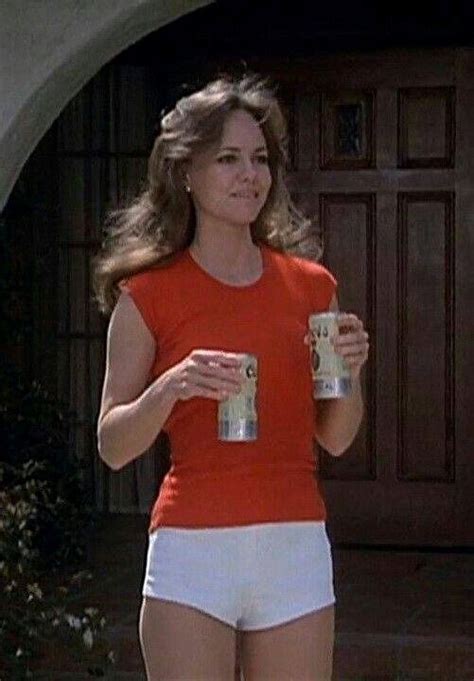 A Woman In White Shorts And An Orange Shirt Is Holding A Can Of Beer