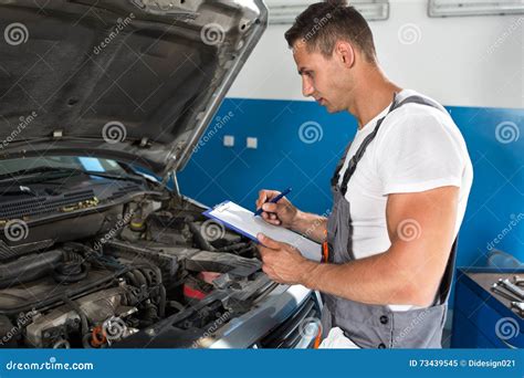 Mechanic Man Holding Clipboard And Check The Car Stock Image Image Of