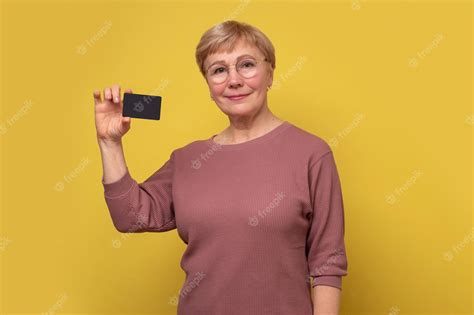 Premium Photo Smiling Mature Woman Showing Empty Card In Hand