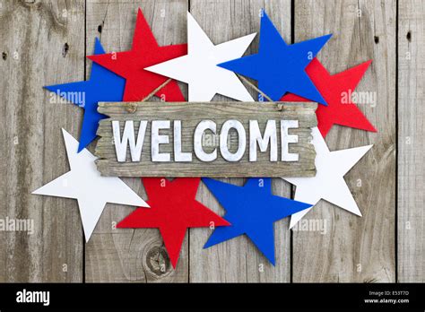 Welcome Sign With Red White And Blue Stars Hanging On Rustic Wooden