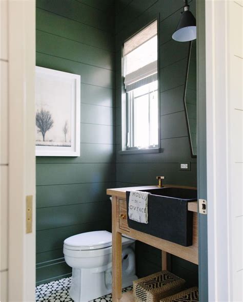 Fabulous bathroom features walls clad in white and brown foliage wallpaper framing window dressed in a matching roman shade accented with a sage green greek key ribbon. 12 Ideas for Gorgeous Green Bathrooms