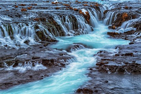 Turquoise Water Flowing Over Rocks Into A River Bruarfoss Iceland