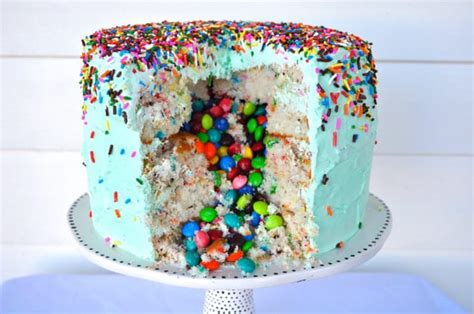 Cake with colorful chocolate candy inside decorated big special occasion party dessert for wedding or birthday celebration. Candy-Filled Funfeti Piñata Cake Recipe by Liz Swartz