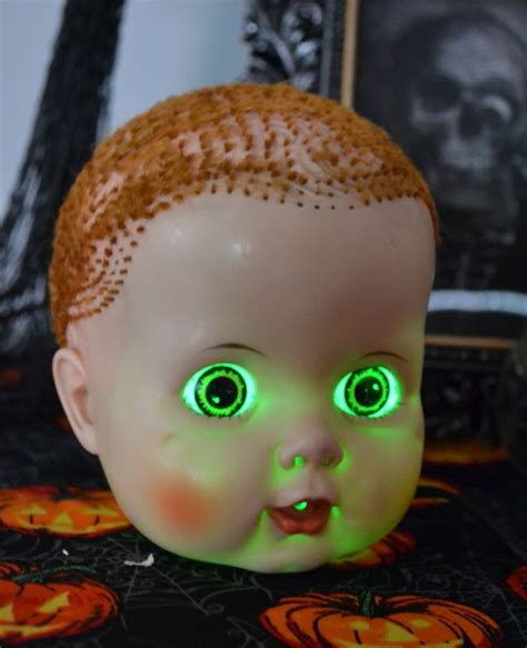 A Creepy Doll With Glowing Green Eyes Sitting On A Table