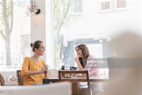 Two Girlfriends Meeting In A Coffee Shop Talking Photo Getty Images