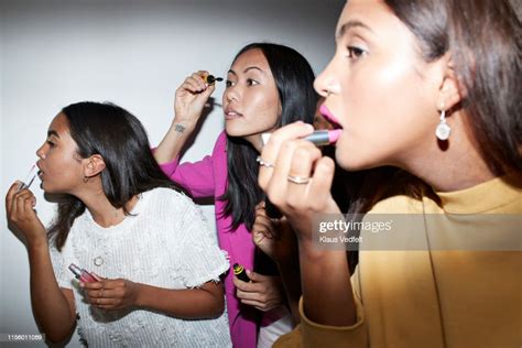 Women Applying Makeup While Standing Together High Res Stock Photo