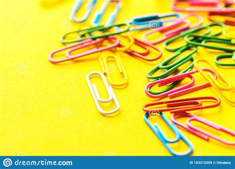 Multicolored Paper Clips Scattered On Bright Yellow Background School