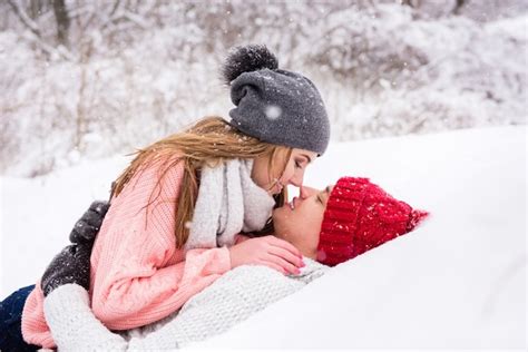 Premium Photo Happy Couple Lay Down And Kissing In Snow