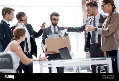 dismissed employee says goodbye to colleagues in the office Stock Photo