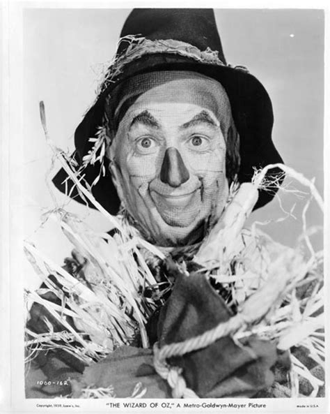 An Old Black And White Photo Of A Man Wearing A Clown Mask With Hay Around His Face