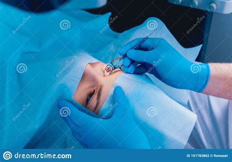 Lasik is an outpatient surgery that corrects vision by reshaping the cornea with a laser. Laser Vision Correction. A Patient And Team Of Surgeons In The Operating Room Stock Photo ...