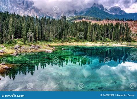 Reflections Of Clouds In The Water Of Lake Carezza Stock Photo Image