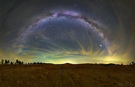 Galactic Arm And Greenish Air Glow Above Steppe Golden Fields From Dark