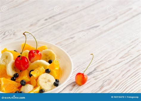 Fruit Salad Of Banana Orange Blueberries And Cherries Stock Photo