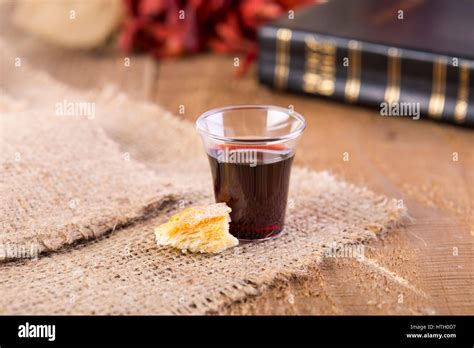 Taking Communion Cup Of Glass With Red Wine Bread And Holy Bible On