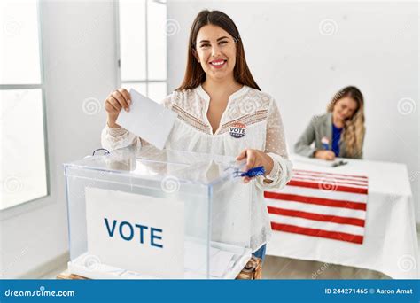 Young American Voter Woman Putting Party Vote In Ballot At Electoral
