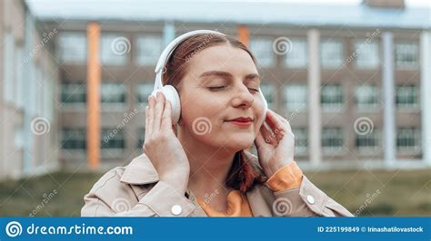 Close Up Portrait Of Young Woman Meditates With Wireless Headphones