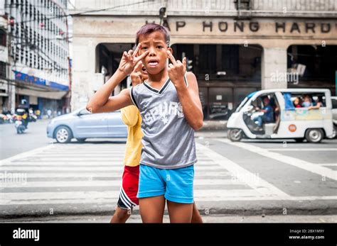 Poor Filipino Street Children Play At A Busy Junction In The China Town