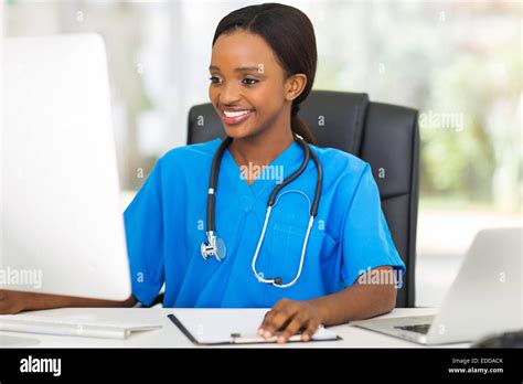 Beautiful Young African Female Doctor Using Computer In Office Stock