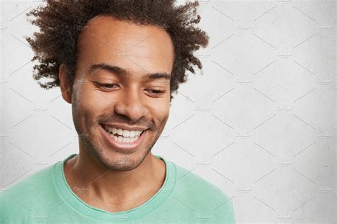 Headshot Of Shy Dark Skinned Male With Crisp Hair Smiles Broadly