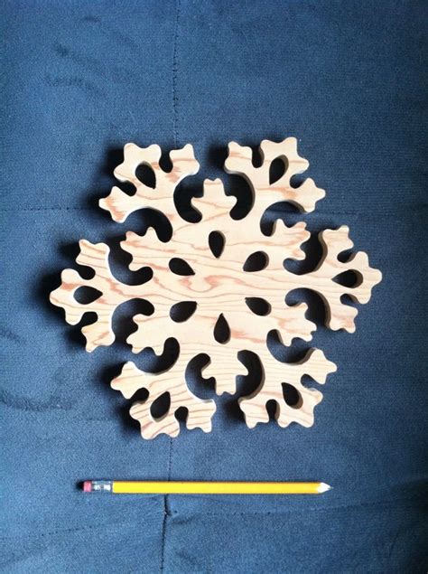 A Wooden Snowflake Next To A Pencil