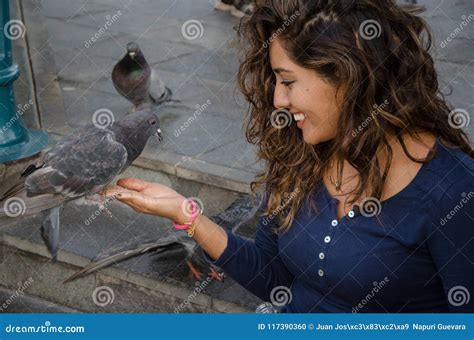 A Smiling Woman Feeding A Pigeon From Her Hand Stock Photo Image Of