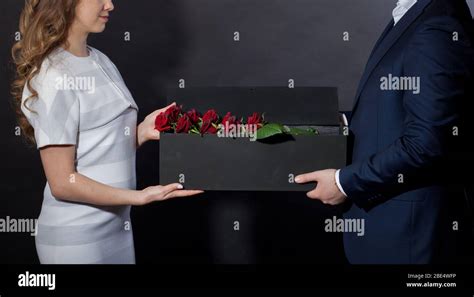 Man Gives Red Roses In An Original Box To His Beloved Woman Stock Photo