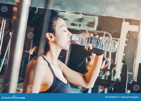 Fitness Woman In Loft Gym Drinking Water After A Good Workout Stock