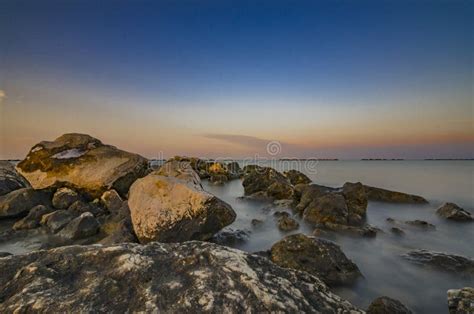 Beautiful Coastal Seascape With Rocks In The Foreground At Sunset Stock