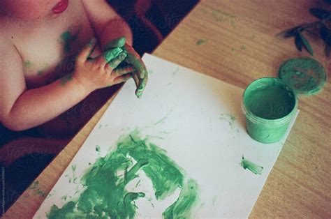 A Beautiful Kid Painting Green With Fingers Del Colaborador De Stocksy Anna Malgina Stocksy