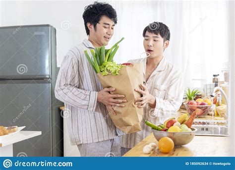 Asian Gay Couple Homosexual Cooking Together In The Kitchen Prepare Fresh Vegetable Make Organic